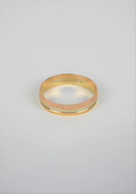gros plan d'une bague en or sur fond blanc