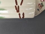 a close up of a vase with a bird on it