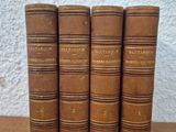 four old books sitting on top of a wooden table