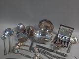 a lot of silver spoons and other silverware on a table