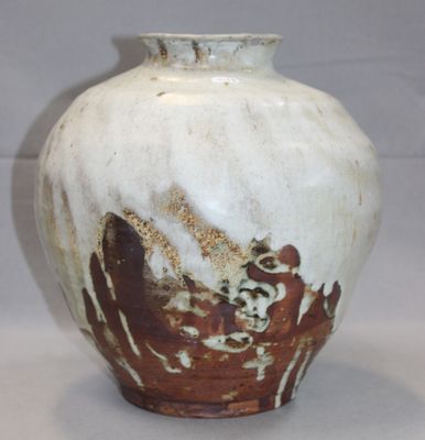un vase blanc et marron posé sur une table