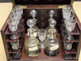 bottles and glasses in a wooden case on display on a table