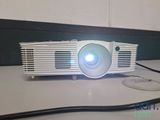 a white projector sitting on a table with a mouse