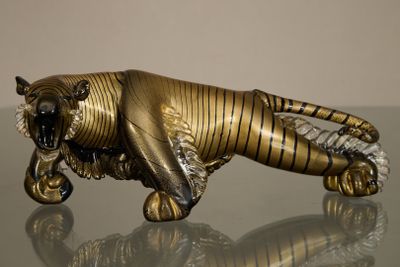 une statue représentant un tigre couché sur une table