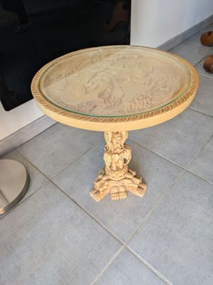 une petite table avec un plateau en verre, posée sur un sol carrelé