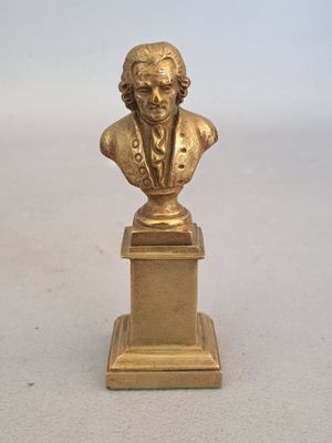 un gros plan sur une statue en or représentant un homme sur un socle