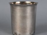 a close up of a silver cup on a gray surface