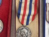 three medals and a medal in a box on a white surface