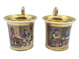 pair of gold and white cups with a painting of a man and a woman in a kitchen