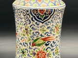 un grand vase orné d'un oiseau, posé sur une table