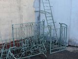 many metal chairs and ladders in front of a wall