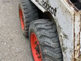 a picture of a bobcat ski - door parked on the side of the road