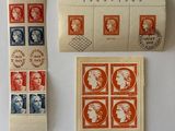 trois timbres et un rouleau de papier posés sur une surface blanche