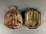 an image of two metal badges with a gold eagle and a shield