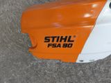 an orange and white chainsaw sitting on the ground