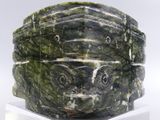 un bol en marbre vert posé sur un socle transparent