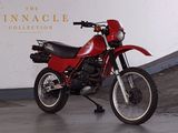 a red motorcycle parked in front of the pinnacle collection sign