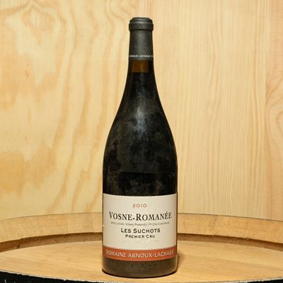 a bottle of wine sitting on top of a wooden barrel