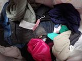 a pile of clothes in a bag on a bed