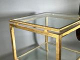 a glass table with a gold frame on top of it