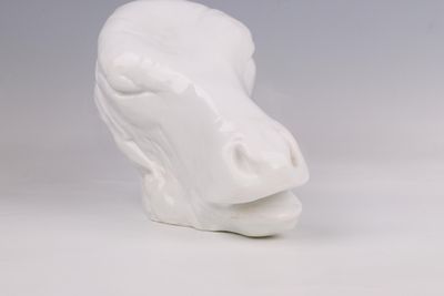 un gros plan sur une sculpture en céramique blanche représentant une vache