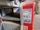 une machine qui découpe un morceau de bois à l'aide d'une scie circulaire