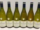 six bouteilles de vin blanc alignées sur une table