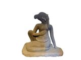 a statue of a woman sitting on a rock