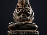 un gros plan sur la statue d'une personne assise sur une table