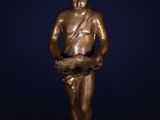 a bronze statue of a boy holding a fish