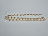 a close up of a gold chain on a white surface