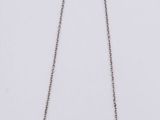 a close up of a necklace on a white surface with a white background