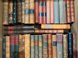 une boîte remplie de vieux livres posée sur une étagère