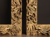 pair of carved wood dragon bookends on a wooden table