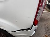 a white truck that has a dent in the back of it