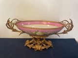 a pink and gold bowl sitting on a blue table