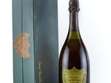 an old bottle of champagne sitting next to a box on a white surface
