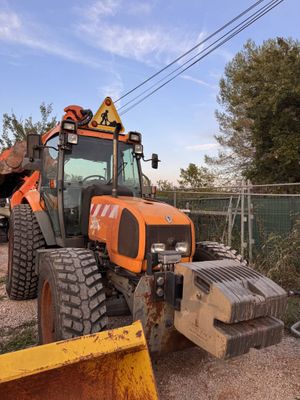 a tractor that is parked next to a yellow plow