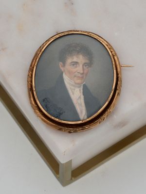 a miniature portrait of a man in a suit on a marble table