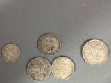 four different types of coins are shown on a gray surface