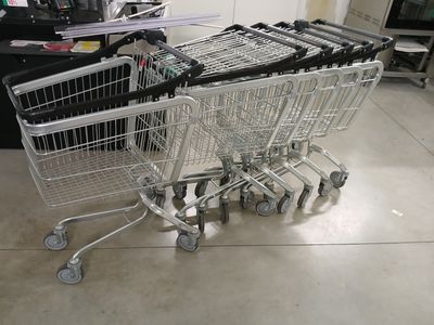 Plusieurs caddies sont alignés les uns à côté des autres dans une pièce