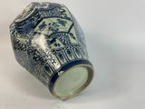 a blue and white vase sitting on a white surface