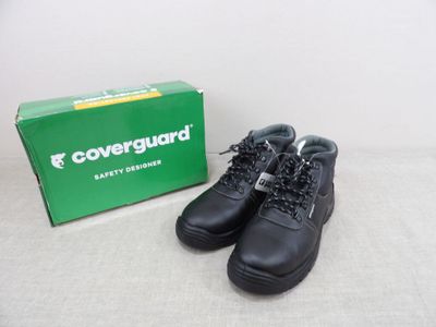 une paire de bottes noires posée à côté d'une boîte verte