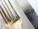 a knife and a fork on a table next to a piece of paper