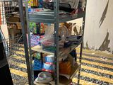 a metal rack with many items on it in a room