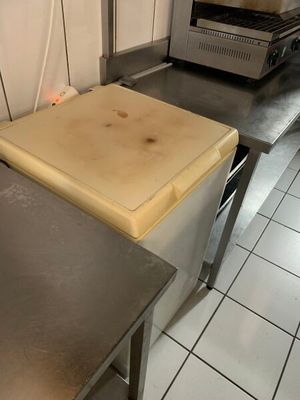 plans de travail en acier inoxydable dans une cuisine professionnelle, avec une cuisinière en arrière-plan