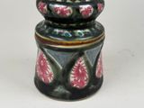 a black and pink vase sitting on a white table