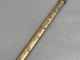 a gold colored pen with a design on it sitting on top of a table