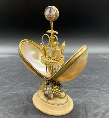 une image représentant un objet plaqué or surmonté d'une horloge