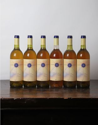 six bouteilles de vin sont alignées sur une table en bois